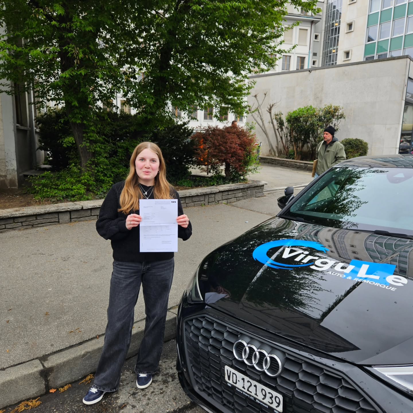 Nola, permis en poche, souriante devant la voiture-école Virgule