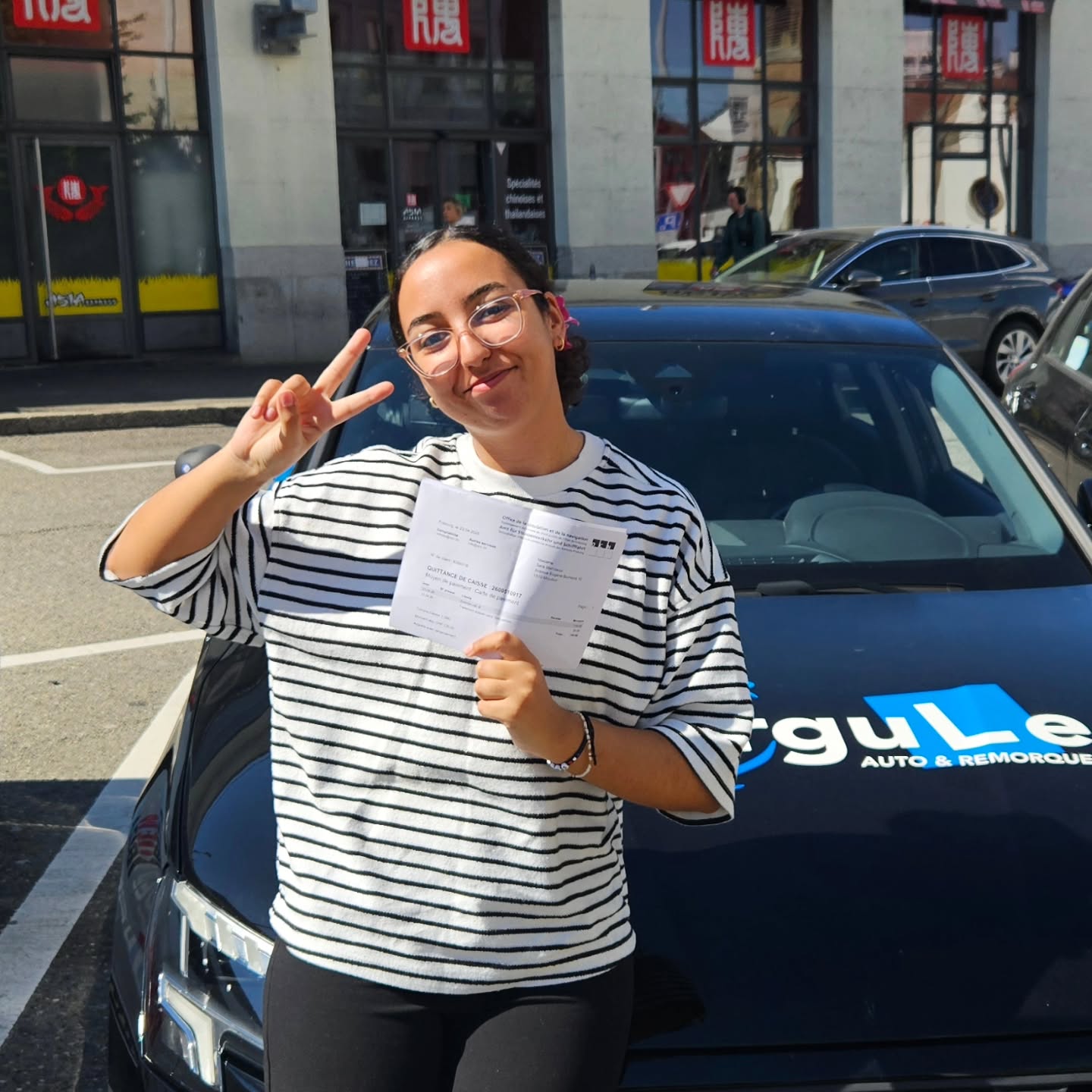 Sara, permis en poche, devant la voiture-école Virgule